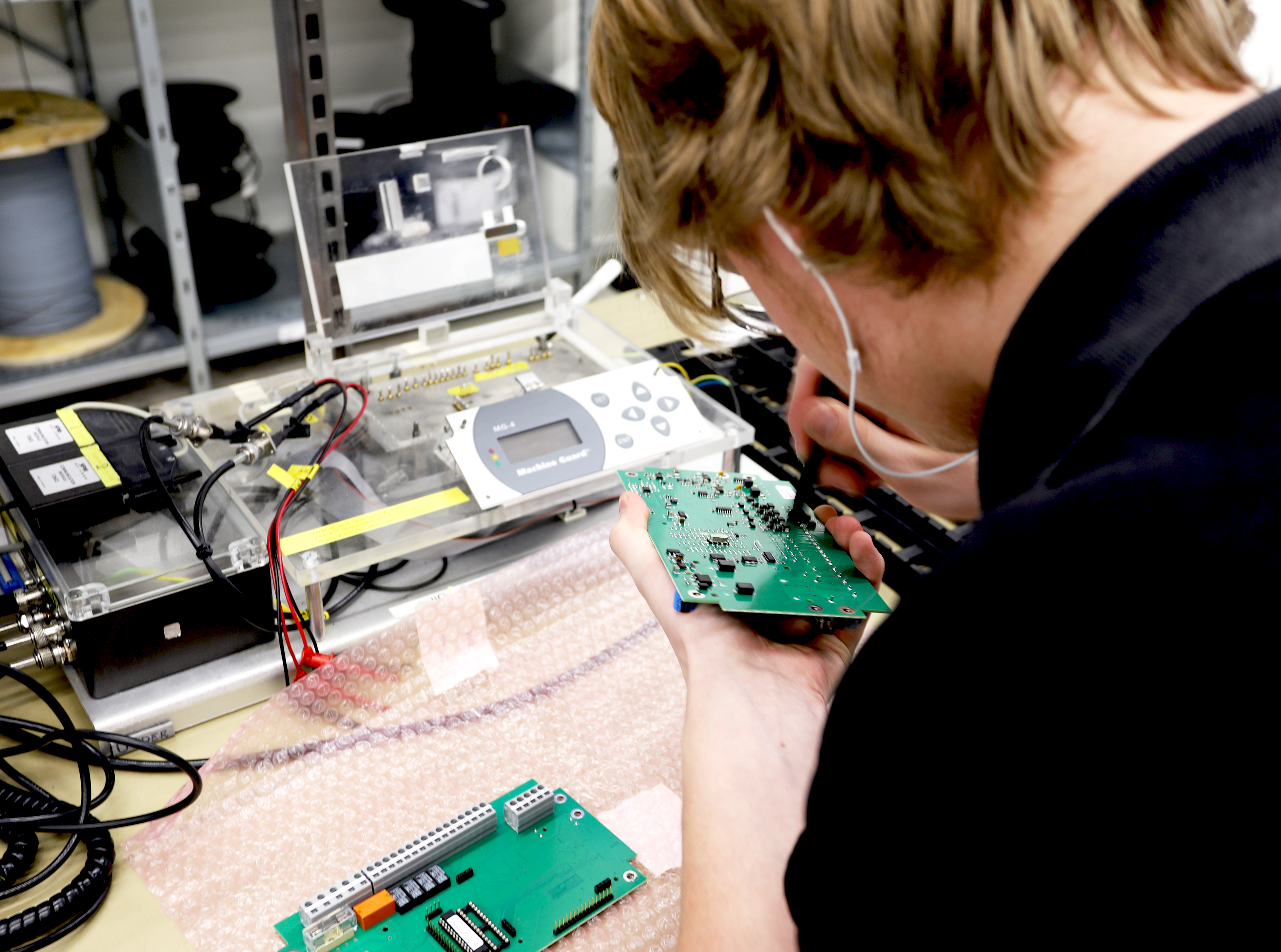 Electronics technician soldering on a circuit board